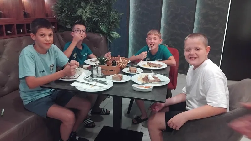 Mladi članovi kluba druže se za stolom van takmičenja.
